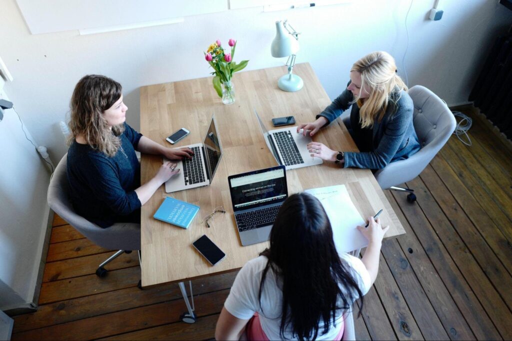 three people working together on laptops
